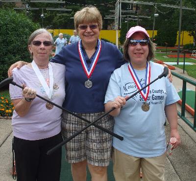 Helena Cribb, Linda Zappacosta, and Linda Desiderio proudly wear their medals.