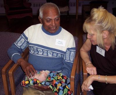 Bhanu Vaghela holds a hairless guinea pig while Caring Paws program aide, Terry Napoli, looks on.