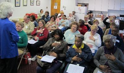 Coach Cheryl Macklin PhD leads Compassion and Self Care group in heart breathing exercises.