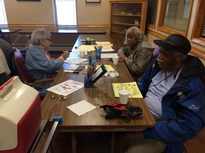 Care receivers Penny Marinakis, Gloria Thompson, and Herbert Pembleton participate in a Creative Arts activity.