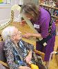 Music and Harp Therapist, Carol Carpenter, plays a personal tune for Evelyn Brennan.